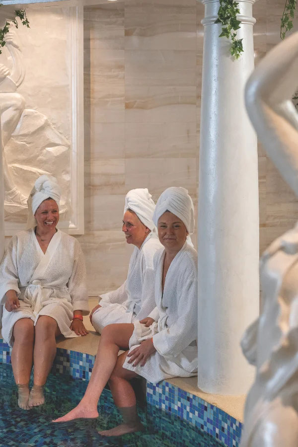 Romersk källa Tjejer sitter vid varma källan i Romerska simhallen på Himmelsby SPA